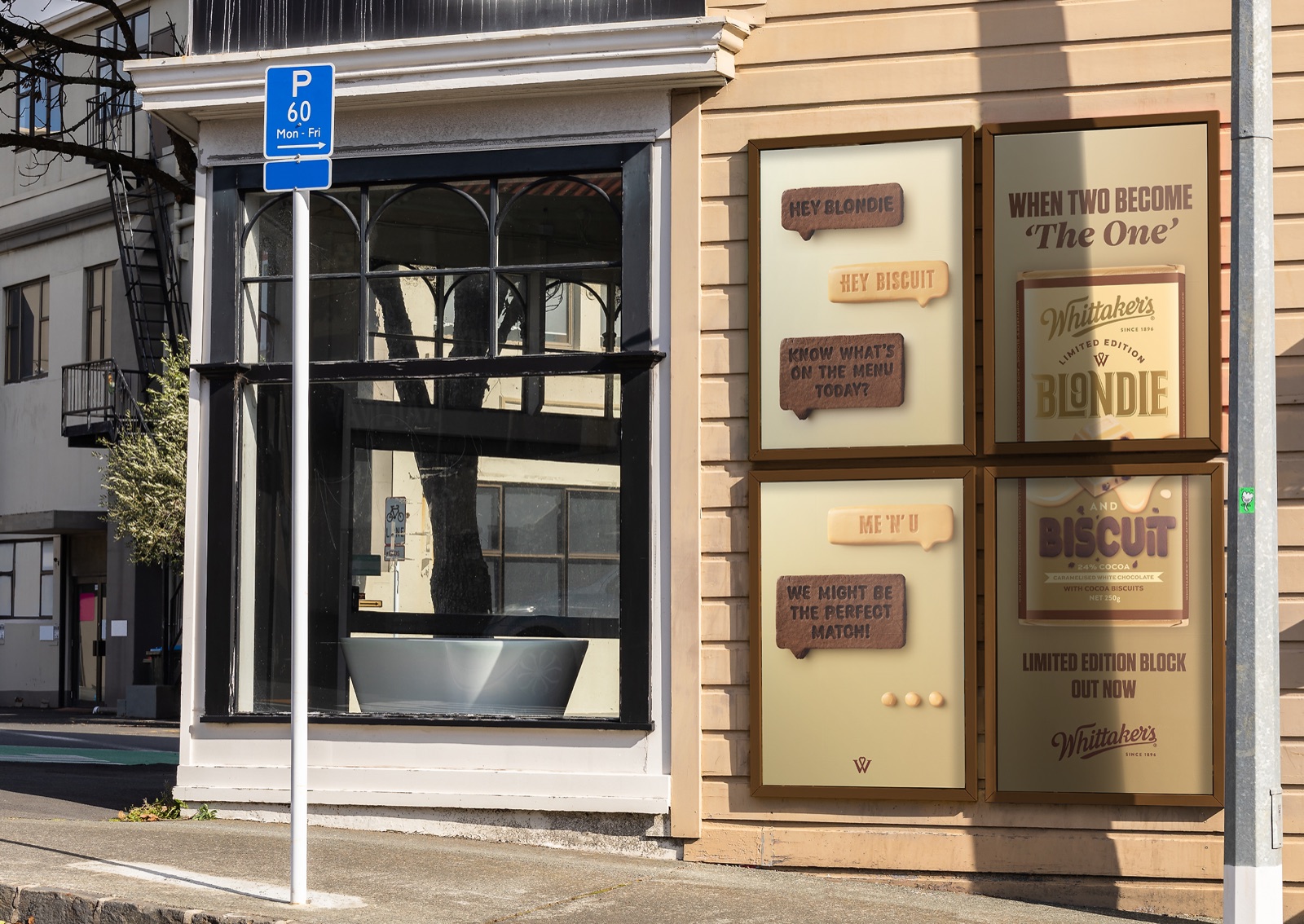 Street-side poster wall showing the Whittaker's Blondie and Biscuit teaser campaign on a building