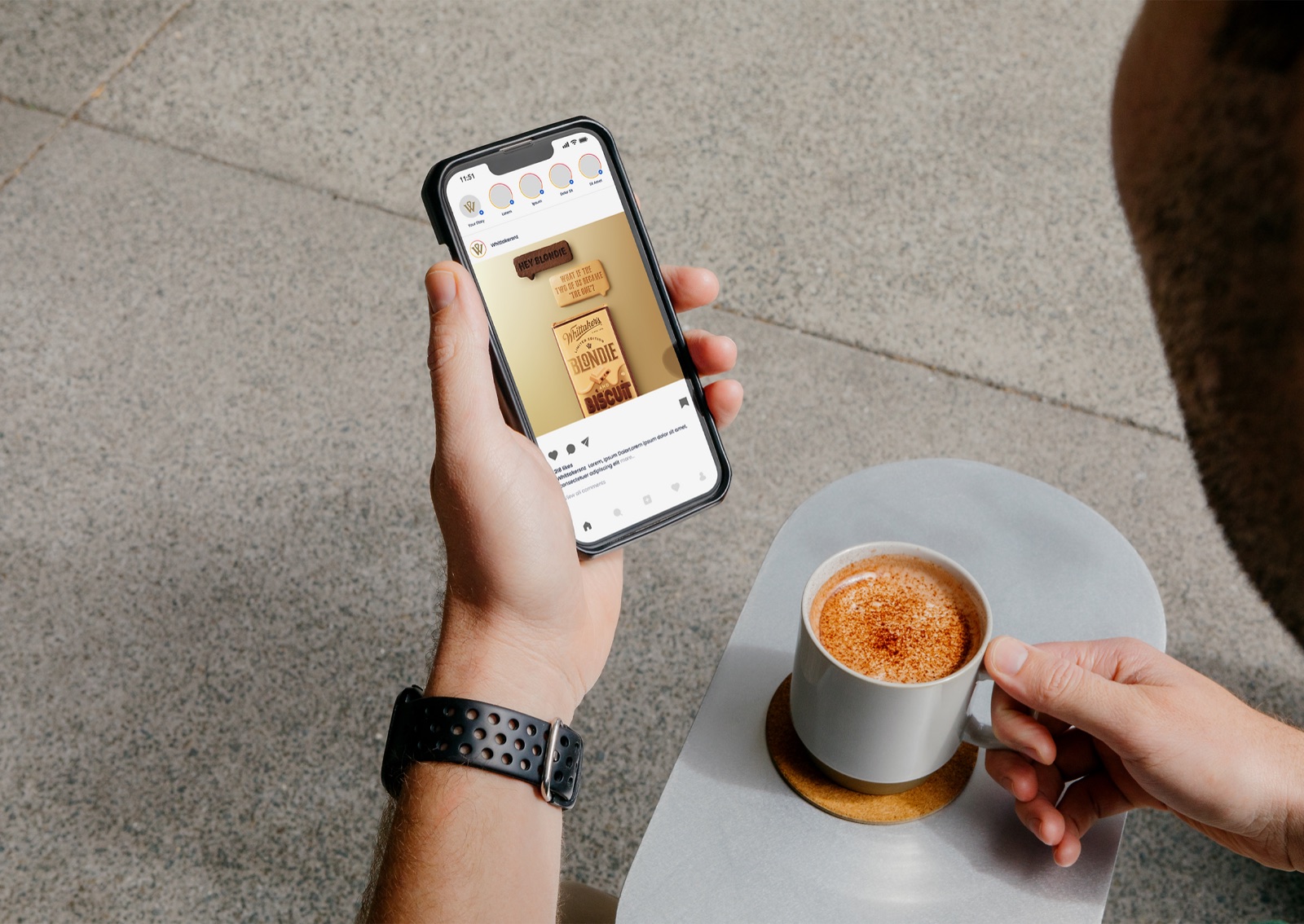 Phone showing a Whittaker's Instagram post for the Blondie and Biscuit launch, beside a coffee cup