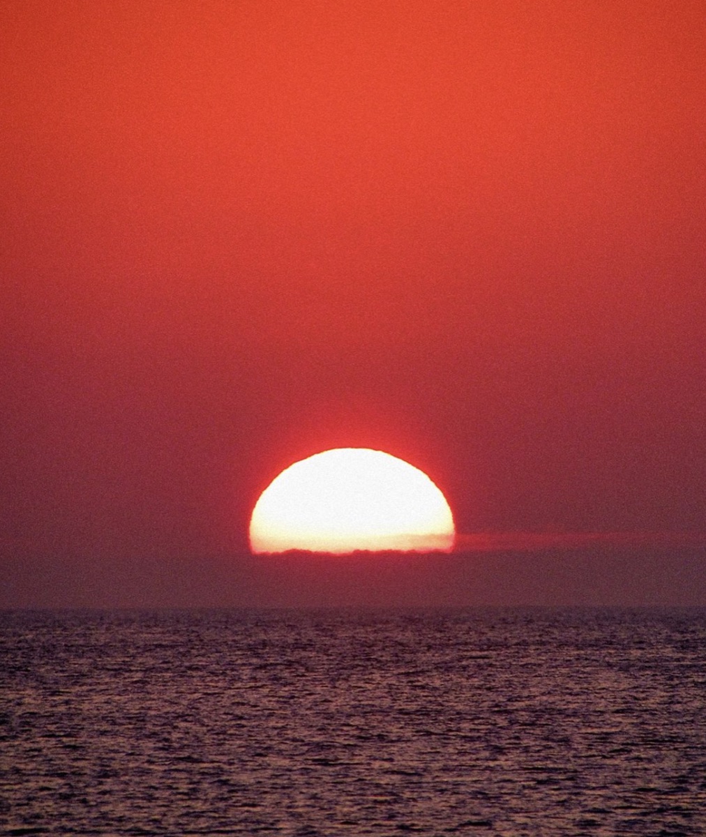 The sun setting over the sea